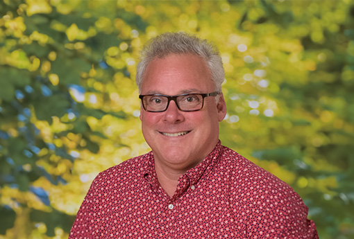 A photo of David Ahlborn outside and smiling at the camera.